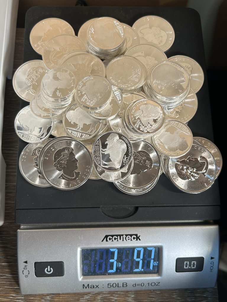 Stack of fractional silver bullion rounds on a scale showing over three pounds of silver with premiums above spot price