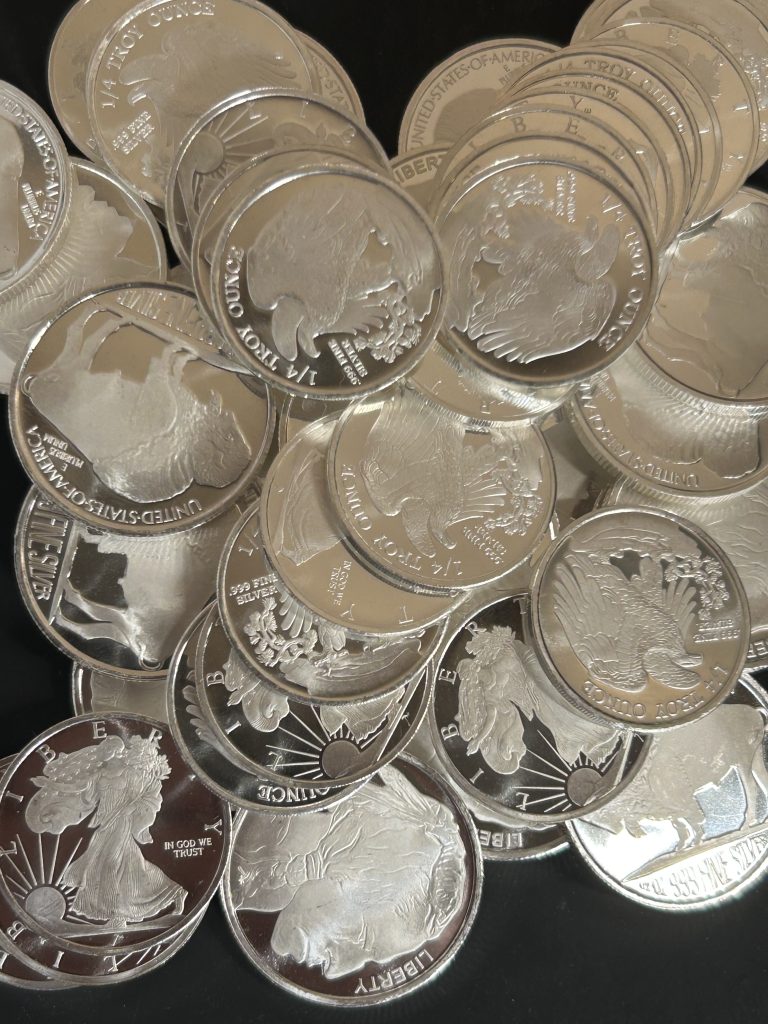 Pile of silver bullion coins showing premium over spot silver value including Buffalo rounds and Walking Liberty style silver rounds
