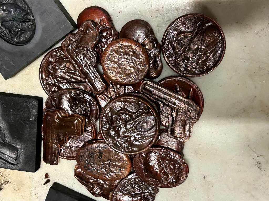 Hand-poured artisan .999 copper bullion rounds and 2 oz antique-finish copper pieces featuring skull pours, marlin designs, and Glock-inspired collectible copper bullion on the SilverPoured Shop Copper page
