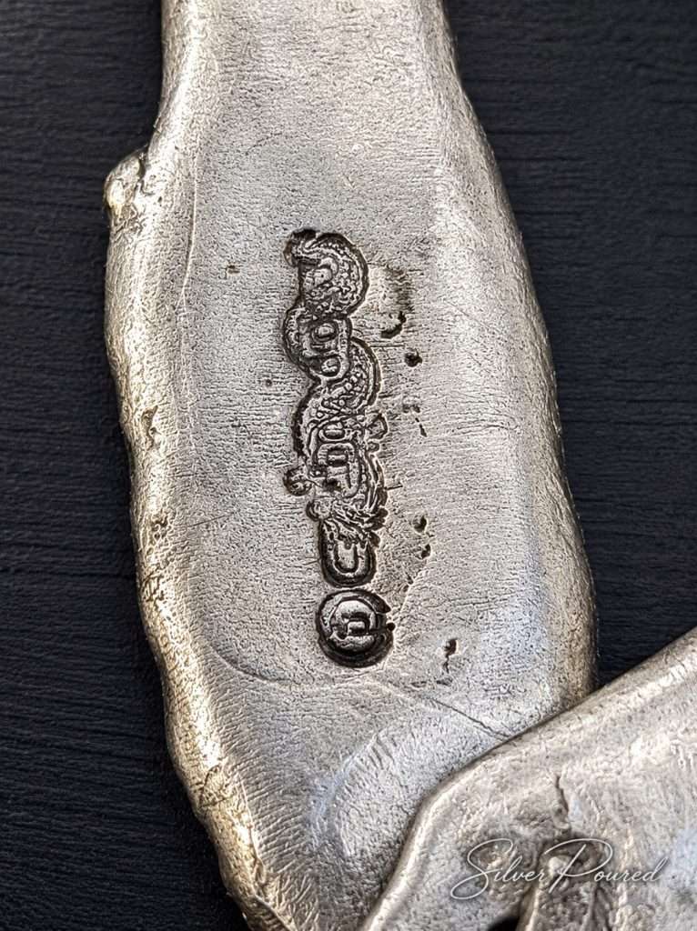 Close-up of the SilverPoured hallmark stamped into a hand poured silver pocket knife, illustrating artisan craftsmanship and authenticity.