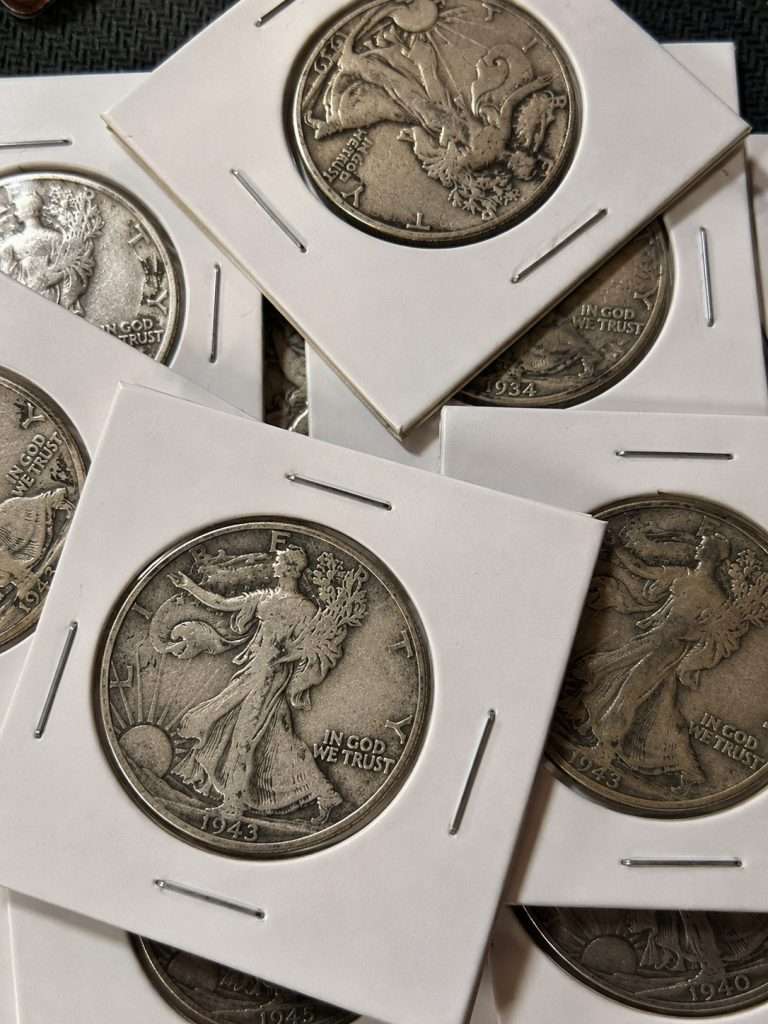 Close-up of Walking Liberty half dollar silver coin lot featuring historic 90% silver U.S. half dollars in protective cardboard holders