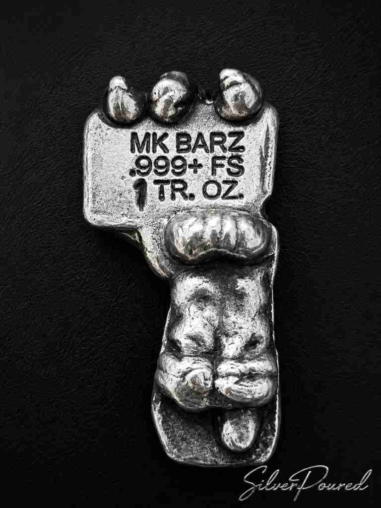 MK Bars .999 fine silver 1 troy ounce hand holding MK Barz sign reverse.